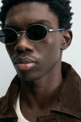 Cazadora de hombre de corte relajado confeccionada en piel con acabado ante, color marrón oscuro. Presenta cuello solapa, manga larga con puños abotonados a presión, bolsillos de vivo en cadera, bolsillo interior y bajo con elástico. Cierre frontal oculto por solapa con botones a presión.