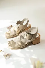 Sandalias de tacón bajo, con tiras cruzadas y diseño en color beige con textura.