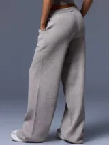 Conjunto de chaleco corto de punto con botones y pantalón de punto con bolsillos grandes y lazo en la cintura, color beige.