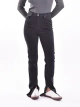 Pantalón de jean negro de tiro alto, corte recto y aberturas en el ruedo.