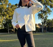 Saco color blanco con botones, cuello redondo y mangas largas.