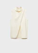 Blusa color crema de tejido fluido satinado, con cuello alto y diseño drapeado.