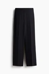 Pantalón negro de vestir, de tiro alto con piernas holgadas rectas con pliegue. Cierre con corchete oculto.