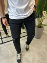 Pantalón de jean negro skinny con roturas en las rodillas.