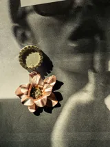 Par de aros colgantes con base circular negra con borde de strass y dije de flor negra con centro de strass.