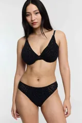 Conjunto de bikini negro con estampado de leopardo, confeccionado en tela flock. El corpiño es de corte triangular y la bombacha es tipo bikini con fundillo de algodón.