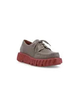 Zapato acordonado color gris con suela de goma color ladrillo.