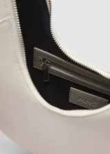 Bolso de hombro negro con efecto piel, forro interior, bolsillo interior con cremallera, cierre de cremallera y asa de hombro. De tamaño mediano.