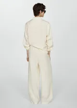 Pantalón wide leg color crema, con cintura elástica y bolsillos delanteros.