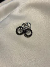 Par de aros colgantes con argollas doradas y dijes circulares de resina transparente con incrustaciones de strass de colores. El dije mide aproximadamente 1.5cm de diámetro.