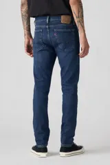 Jeans de mezclilla azul oscuro, corte skinny, con cierre de botones y tiro medio.