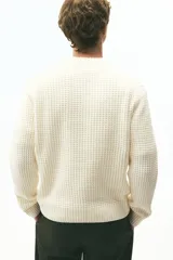 Buzo de punto texturizado suave de chenille, color crema, con cuello redondo ribeteado, hombros caídos y puños y bajo en punto acanalado.