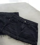 Minifalda de jean negro con lavado gastado y ruedo desflecado.