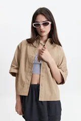 Camisa color beige de corte oversize y manga corta.