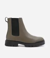 Bota Chelsea color verde oliva, confeccionada en cuero sintético, con laterales elásticos negros y suela track negra.
