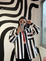 Camisa oversize de jean rayado blanco y negro con bolsillo con bordado de corazón con fuego y botones de acrílico en forma de corazón.