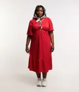Vestido midi rojo de malla texturizada, con escote en pico, mangas cortas, aro central en el escote y recorte cutout lateral en la cintura.