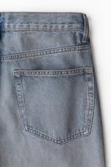 Pantalón de jean celeste con efecto desgastado, corte recto y tiro alto.