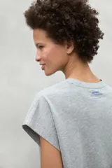 Camiseta gris de manga corta con cuello redondo y texto estampado en el pecho.