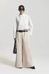 Pantalón de gabardina liviana color negro, de tiro medio y pierna ancha tipo palazzo con tablas en el delantero.