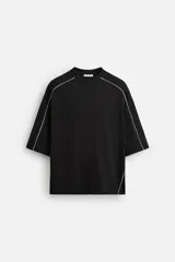 Sudadera negra de corte relaxed fit, cuello redondo y manga corta. Presenta vivos blancos en contraste en hombros y mangas.