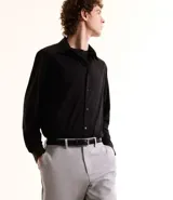 Camisa de manga larga color negro, con cuello inglés y abotonado frontal. Confeccionada en tejido piqué de poliamida y elastano, con tecnología performance que ofrece elasticidad, secado rápido y menor arrugado.