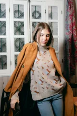 Sweater beige con cuello alto y estampado de anclas en gris.