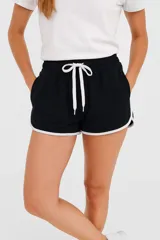 Short negro de algodón con cintura elástica y ribete blanco en el ruedo.