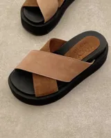 Sandalias Lucy de cuero color beige con tiras cruzadas y suela plana.