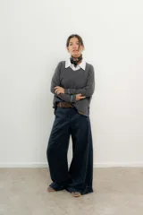 Pantalón de vestir azul marino, de corte palazzo, con bolsillos laterales y cintura alta. Se ajusta a la cintura con cinturón de cuero marrón con hebilla dorada.