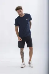 Remera de manga corta color verde azulado con cuello redondo y estampado frontal con el texto "UH3" en blanco.