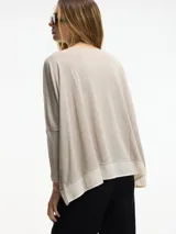 Sweater negro de fit amplio con mangas ajustadas y detalle de superposición en el bajo.