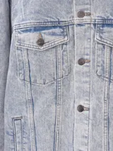 Campera de jean negra con botones metálicos, bolsillos frontales con solapa y cuello clásico.