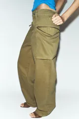 Jeans cargo de tiro medio color verde militar, con pernera recta. Presenta bolsillos laterales de plastrón con cierre de cremallera y cierre frontal con cremallera y botón.