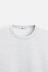 Sudadera negra de corte holgado, cuello redondo y mangas largas con puños acanalados.