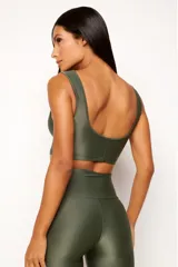 Top deportivo color ladrillo, de poliamida con acabado brillante y textura acanalada, con cuello redondo y espalda escotada.