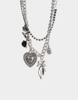 Collar corto plateado con múltiples cadenas y dijes colgantes: rosas, corazón y moño.