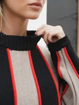 Sweater de tejido de punto con rayas horizontales en blanco y negro, con ribete marrón en los bordes.