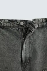 Pantalón gris de corte relaxed fit, con cinco bolsillos, efecto lavado, aplicación de tira y bolsillo multifunción en perneras. Cierre frontal con cremallera y botón.