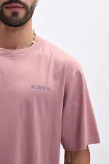 Remera manga corta color rosa con estampa azul en la espalda que dice 'I OWN SWAGGER' y coordenadas geográficas.