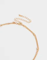 Collar corto doble dorado, con cadena de esferas, dije de corazón y dije de cruz con strass.