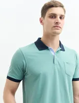 Remera polo blanca de piqué con cuello y puños en azul marino. Tiene tapeta de dos botones y bolsillo de parche en el pecho.
