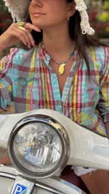 Camisa de algodón a cuadros multicolor con cuello camisero, mangas largas abullonadas y cierre frontal con botones. Diseño holgado y estilo divertido.