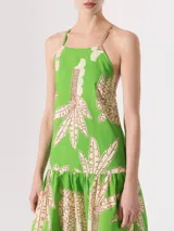 Vestido largo verde con estampado de palmeras, de breteles finos y espalda descubierta.