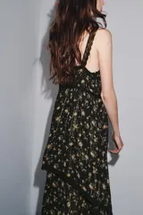 Vestido negro con estampado floral, escote recto y tirantes finos. Detalle de aplicación de hilo metalizado, lentejuelas y puntilla combinadas a tono. Bajo asimétrico.