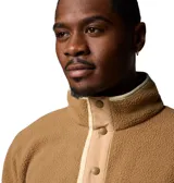 Buzo polar color marrón con cuello alto abotonado, bolsillo con cremallera en el pecho, puños y dobladillo elásticos.