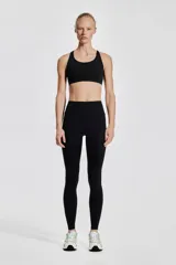 Calzas deportivas negras de tiro alto con bolsillos laterales, confeccionadas en tejido funcional DryMove™ que absorbe la humedad.