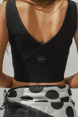 Top corto color crema, de tejido de punto acanalado, con escote en V y breteles anchos.