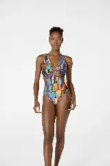 Traje de baño enterizo con estampado de plumas multicolores, escote en V con detalle de aro metálico y aberturas laterales.