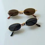 Lentes de sol con filtro UV400, de forma ovalada con marco dorado y lentes marrones y negros.